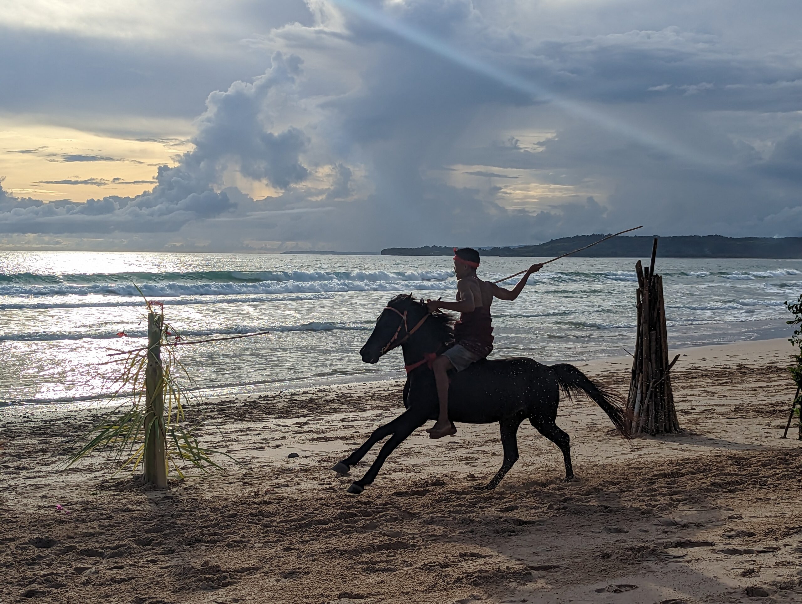 Horse back rider with hunting staff on beach